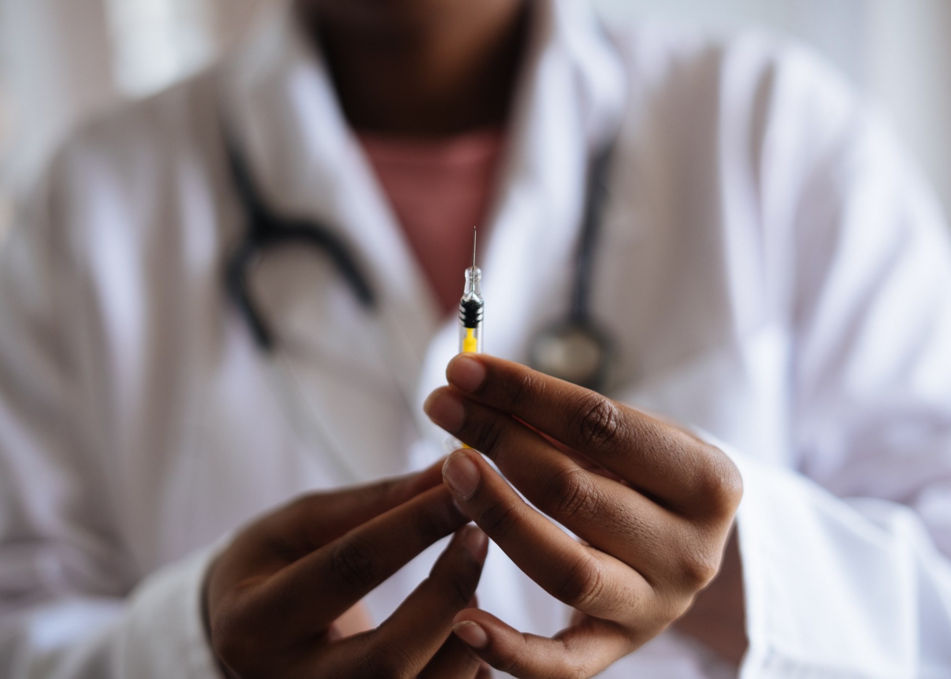 Person holding vaccine dose in syringe